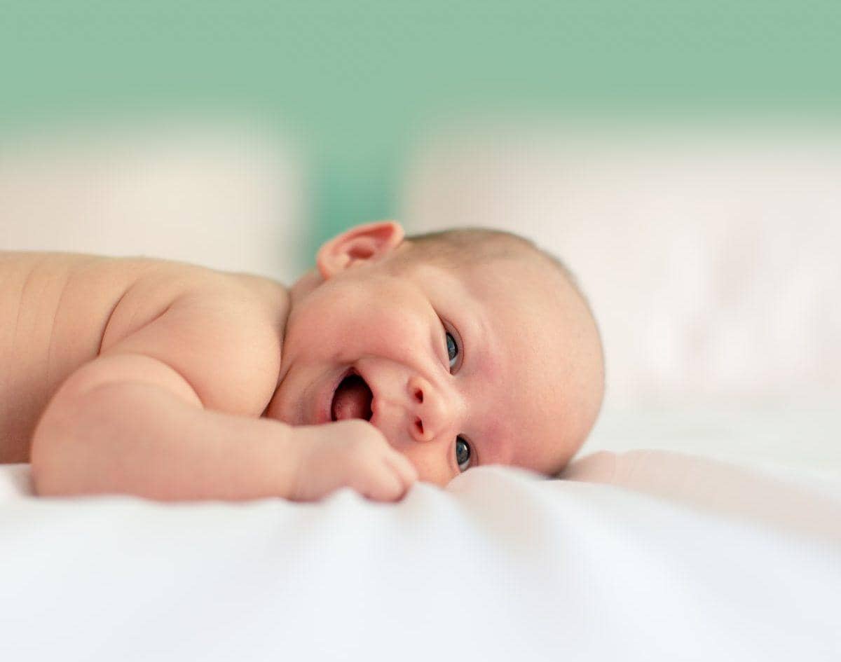 baby lying on fabric cloth